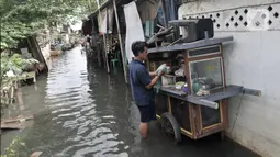 Aktivitas warga di tengah banjir yang masih merendam Kampung Rawa Indah, Jakarta Utara, Senin (24/2/2020). Kampung yang terletak di dua kelurahan, yakni Sukapura dan Pegangsaan Dua tersebut masih terendam banjir hingga sore ini dengan ketinggian air 30-50 cm. (merdeka.com/Iqbal S Nugroho)