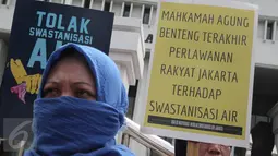 Seorang pendemo saat menggelar aksi membawa atribut poster menolak swastanisasi air Jakarta, di depan Gedung Mahkamah Agung, Jakarta, Jumat (3/6). Mereka meminta MA memutus secara adil dan bijak hak atas air. (Liputan6.com/Faizal Fanani)