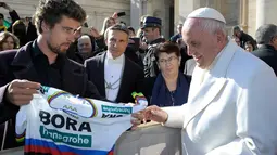 Juara sepeda Slovakia Peter Sagan menawarkan jersey yang dipakai saat menjadi juara dunia kepada Paus Fransiskus pada akhir audiensi mingguan di Vatikan (24/1). (AFP/HO/Osservatore Romano)