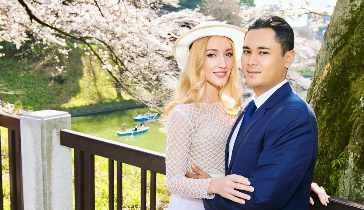 Kemesraan Panji dan Varsha Strauss saat berada di Jepang. Terlihat elegan dengan latar belakang sungai dan bunga sakura (Liputan6.com/IG/@varshaadhikumoro)