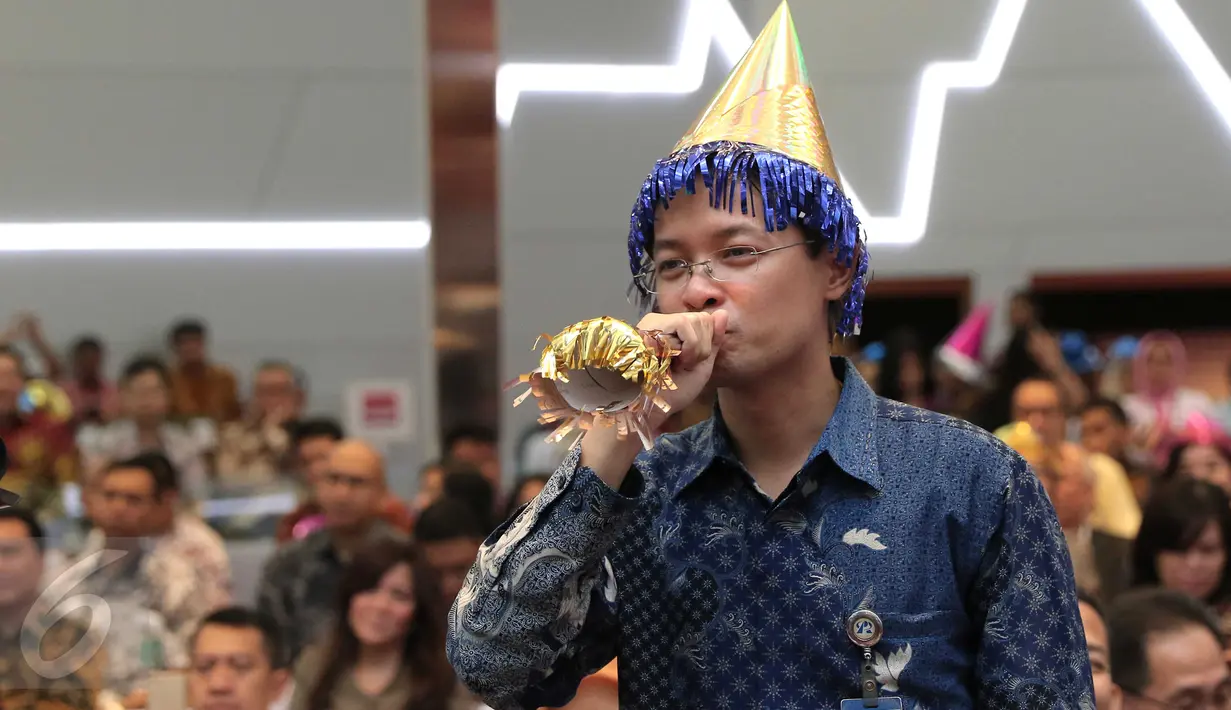 Pegawai mengenakan topi dan meniupkan trompet usai penutupan perdagangan saham tahun 2015 di Bursa Efek Indonesia, Jakarta, Rabu (30/12). Indeks Harga Saham Gabungan (IHSG) pada akhir perdagangan 2015 ditutup hari ini‎. (Liputan6.com/Angga Yuniar)