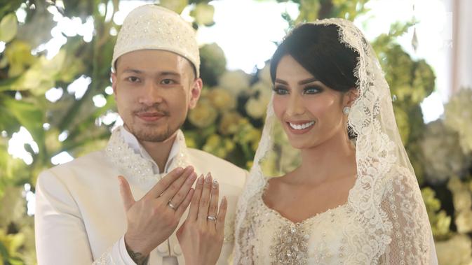 Aktris Tyas Mirasih dan suaminya Raiden Soedjono menunjukkan cincin pernikahan usai ijab kabul di kawasan Cilandak, Jakarta (8/7). Tyas Mirasih menikah dengan Raiden Soedjono dengan mas kawin perhiasan emas delapan gram. (Liputan6.com/Herman Zakharia)