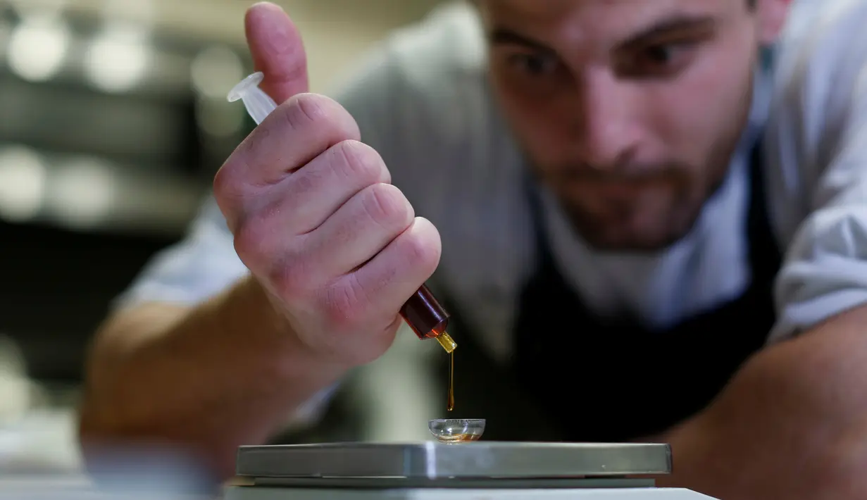Chef Christopher Sayegh menimbang minyak THC (Tetrahydrocannabinol), dan CBD (Cannabidiol) yang akan digunakan sebagai campuran bahan masakan di sebuah restoran di Los Angeles, AS (29/4). (Reuters/ Mario Anzuoni)