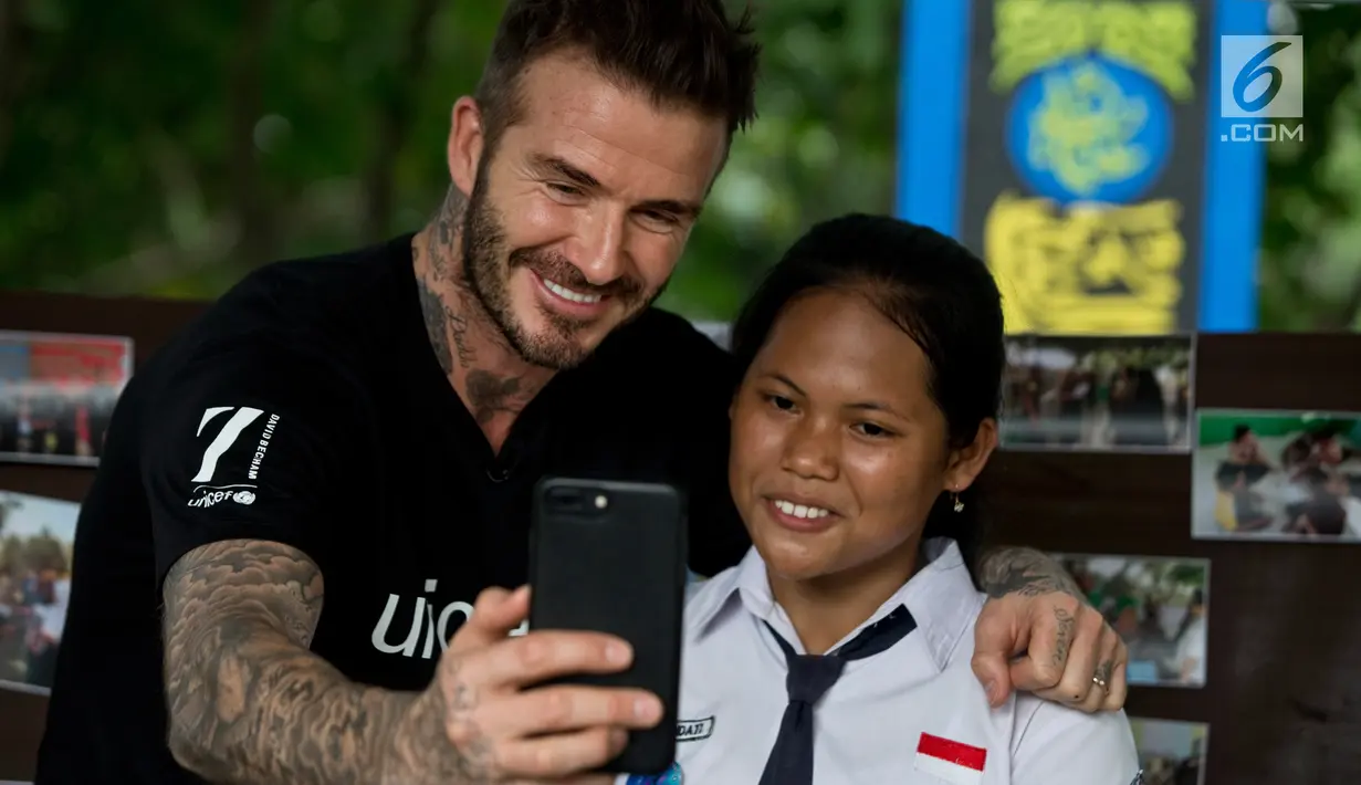 Mantan pesepakbola David Beckham berswafoto dengan siswi SMPN 17 Semarang, Sripun dalam kunjungannya sebagai Duta Kehormatan UNICEF ke Jawa Tengah, Rabu (28/3). Bersama Unicef, Beckham tengah melakukan kampanye anti-perundungan. (Liputan6.com/Pool/UNICEF)