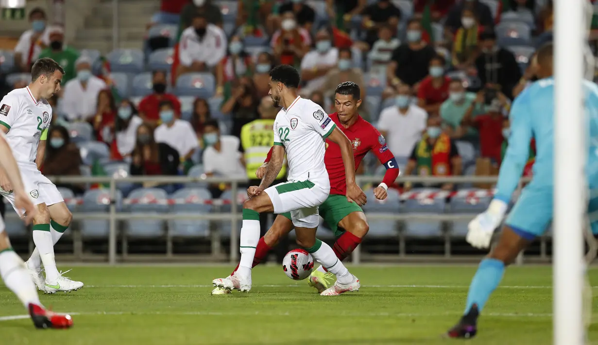 Pemain Portugal Cristiano Ronaldo melepaskan diri dari pemain Irlandia Andrew Omobamidele pada pertandingan kualifikasi grup A Piala Dunia 2022 di Stadion Algarve, luar Faro, Portugal, Rabu (1/9/2021). Ronaldo mencetak dua gol saat Portugal menang 2-1. (AP Photo/Armando Franca)