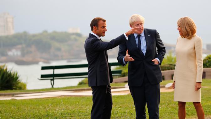 Presiden Prancis Emmanuel Macron (kiri) dan istrinya Brigitte Macron (kanan) menyambut kedatangan Perdana Menteri Inggris Boris Johnson (tengah) di KTT G7, Biarritz, Prancis, Sabtu (24/8/2019). (AP Photo/Francois Mori, Pool)