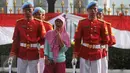 Seorang warga berfoto diantara anggota Paspampres di depan Istana Negara, Jakarta, Minggu (17/7). Prosesi pergantian pasukan penjaga Istana Negara merupakan kegiatan rutin yang dilangsungkan pada Minggu ke-2 tiap bulannya. (Liputan6.com/Gempur M Surya)