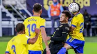 Penyerang Barcelona, Philippe Coutinho, duel udara dengan pemain Cadiz, Jairo Izquierdo, pada laga Liga Spanyol di Stadion Ramon Carranza, Minggu (6/12/2020). Barcelona takluk dengan skor 1-2. (AP/Alvaro Rivero)