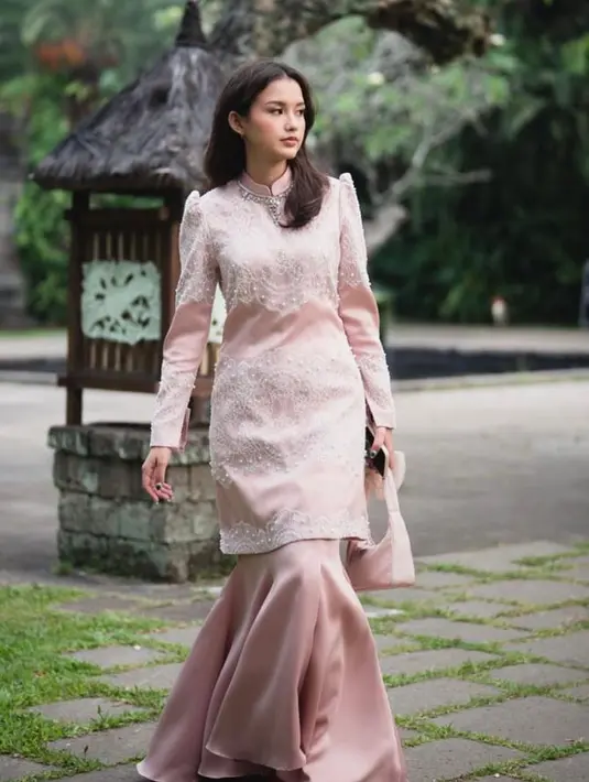 Gadis asal Bali itu terlihat anggun dalam balutan tunik beraksen puff sleeve dan detail beads, dipadukan dengan long skirt bersiluet duyung.