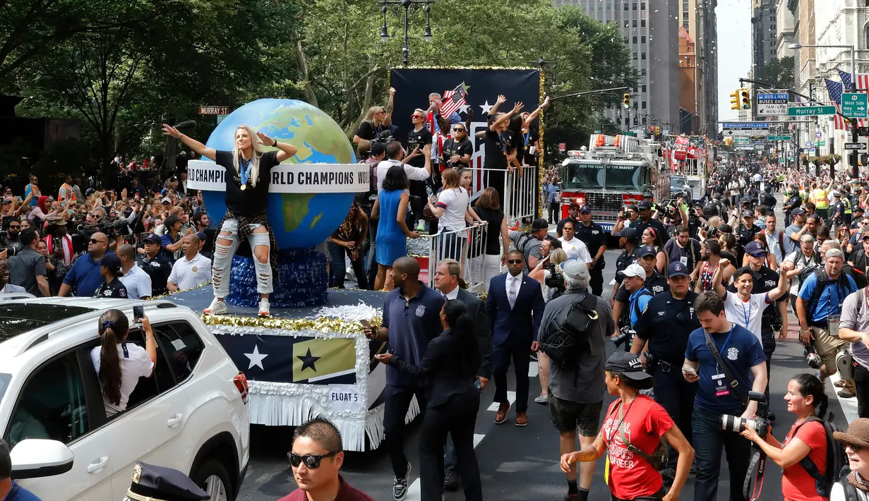 Pemain timnas sepak bola wanita Amerika Serikat (AS), Julie Ertz (kiri) bersama rekan-rekannya menaiki kendaraan hias saat parade kemenangan Piala Dunia Wanita 2019 di New York, AS, Rabu (10/7/2019). AS menjuarai Piala Dunia Wanita 2019 usai mengalahkan Belanda di final. (AP Photo/Richard Drew)
