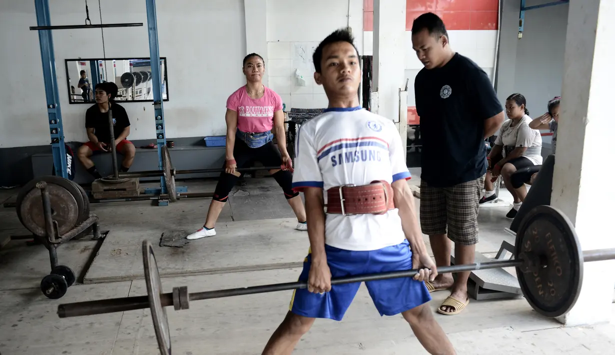 Seorang anak berusaha mengangkat besi disaksikan rekan-rekanya saat berlatih di Padepokan Gajah, sebuah akademi swasta di Pringsewu, Kabupaten Lampung, Sumatera Selatan (7/11). (AFP Photo/GOH Chai Hin)