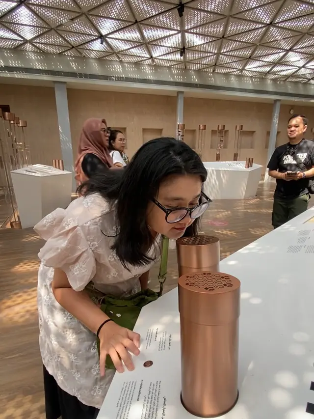 Mencium salah satu aroma parfum di Parfum House. [Anisha/Fimela]