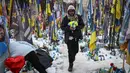 Konflik ini telah berkembang menjadi perang yang paling mematikan di Eropa sejak Perang Dunia II. Tampak dalam foto, seorang warga setempat mengunjungi tugu peringatan sementara untuk tentara Ukraina di Lapangan Kemerdekaan, Kyiv, saat peringatan keempat invasi Rusia ke Ukraina, Selasa 24 Februari 2026. (HENRY NICHOLLS/AFP)