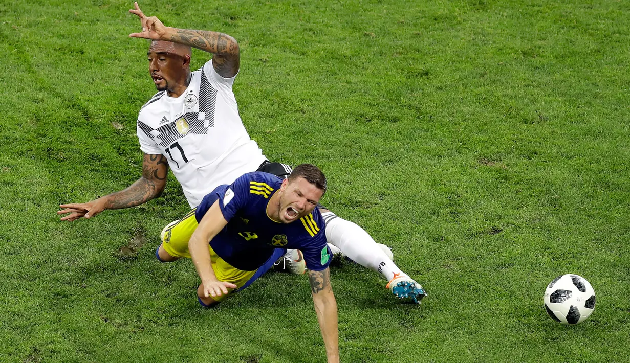 Pemain Jerman Jerome Boateng melakukan pelanggaran terhadap pemain Swedia Marcus Berg saat pertandingan Piala Dunia 2018 di Stadion Fisht, Rusia (23/6). Karena pelanggaran ini Boateng mendapat kartu kuning kedua. (AP/Sergei Grits)