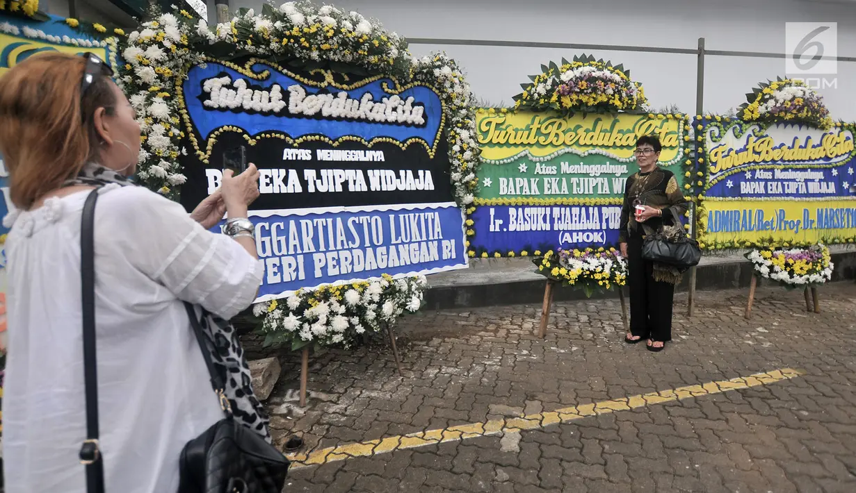 Pelayat foto dengan karangan bunga untuk mendiang Eka Tjipta Widjaja di Rumah Duka Sentosa RSPAD Gatot Soebroto, Jakarta, Minggu (27/1). Basuki Tjahaja Purnama atau Ahok mengirim karangan bunga sebagai bentuk belasungkawa. (Merdeka.com/Iqbal Nugroho)