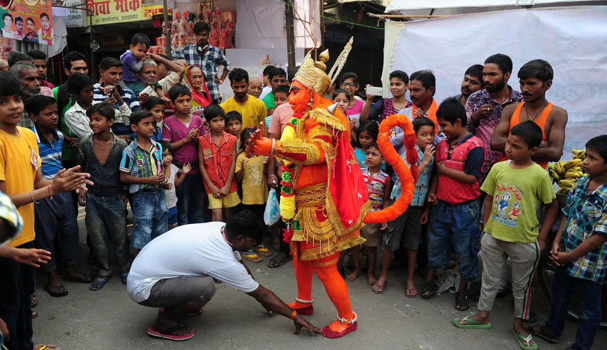 Seorang pria India berpakaian seperti dewa monyet Hanoman memberkati warga setempat saat prosesi festival Jayanti di Allahabad, India (18/10). Festival ini untuk memperingati kelahiran dewa Hindu Hanoman. (AFP Photo/Sanjay Kanojia)