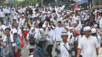 Peserta demo 2 Desember terlihat masih berjalan menuju Monas dari arah Tanah Abang, Jakarta, Jumat (2/12). Tidak hanya kaum pria, tampak kaum perempuan juga turut dalam aksi doa bersama di Monas. (Liputan6.com/Helmi Afandi)