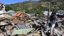 Seorang pria menyelamatkan sisa-sisa puing dari bangunan rumah yang rusak di Menggala, Lombok Utara, Rabu (8/8). Warga terdampak gempa Lombok mulai mengamankan barang berharga miliknya karena kuatir dijarah pihak tidak bertanggung jawab. (AFP/ADEK BERRY)