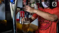 Pekerja menyiapkan minuman keras atau miras di mesin pendingin di salah satu kafe kawasan Jakarta Selatan, Selasa (2/3/2021). Aturan yang diteken oleh Presiden Joko Widodo pada 2 Februari 2021 terkait memperbolehkan masyarakat untuk berinvestasi di produk miras dicabut. (Liputan6.com/Johan Tallo)