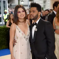 The Weeknd yang hadir dengan setelah jasnya berwarna hitam membuatnya begitu gagah dan tampan. Sedangkan Selena yang memakai gaun berwarna putih yang bermotif sederhana, dipadu tatana rambut yang dibiarkan terurai. (AFP/Bintang.com)