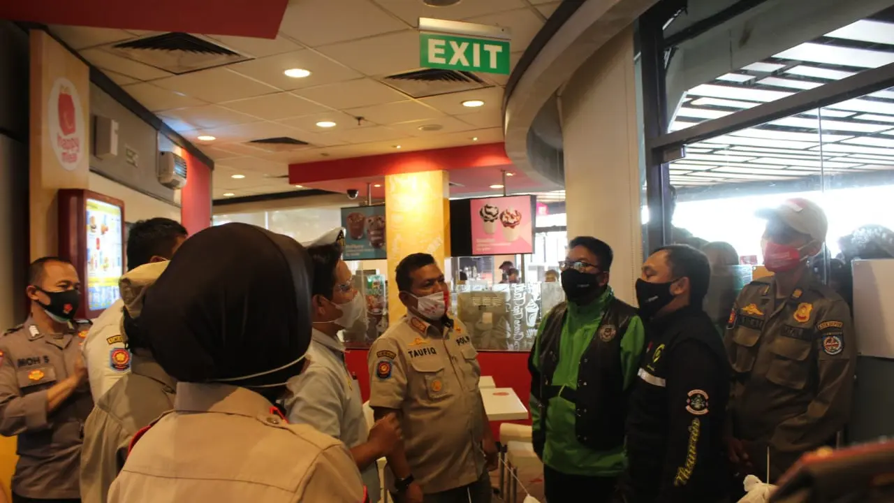 Satpol PP Kota Depok saat membubarkan kerumunan restoran cepat saji McDonald's di pusat perbelanjaan Kota Depok.