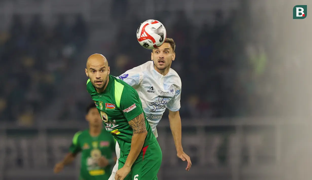 Pemain Persebaya, Risto Mitrevski berduel dengan pemain PSIM Yogyakarta, Nermin Haljeta pada pertandingan pembuka BRI Super League 2025/2026 di Stadion Gelora Bung Tomo, Jumat (08/08/2025) malam WIB. (Bola.com/Abdul Aziz)