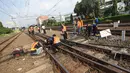 Petugas memperbaiki rel Kereta rel listrik (KRL) Jabodetabek rute Depok-Jatinegara yang mengalami anjlok di Stasiun Jatinegara, Jakarta Timur, Senin (30/10). Peristiwa itu berdampak keterlambatan perjalanan kereta lainnya. (Liputan6.com/Immanuel Antonius)