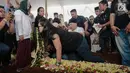 Anak komedian Indro Warkop mencium nisan ibunya, Nita Octobijanthy saat pemakaman di TPU Tanah Kusir, Jakarta, Rabu (10/10). Putri Indro, Satya Paramita Hada Dwinita berkali-kali menangis saat pemakaman sang bunda. (Liputan6.com/Faizal Fanani)