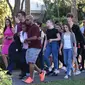 Sejumlah siswa dievakuasi ketika terjadi  penembakan massal sekolah menengah atas Marjory Stoneman Douglas di Parkland, Florida, Rabu (14/2). Insiden itu melukai sejumlah orang dan membuat ratusan murid berlarian ke jalanan. (Michele Eve Sandberg/AFP)