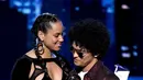 Penyanyi Bruno Mars menerima trofi Record of the Year dari Alicia Keys pada ajang Grammy Awards 2018 di New York City, Minggu (28/1). Dengan album 24K Magic, Bruno merebut enam trofi Grammy termasuk Record of the Year. (Kevin Winter/Getty Images/AFP)
