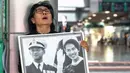 Seorang pelayat Thailand, Kanjana Malaithong, memegang potret Ratu Thailand yang telah wafat, Sirikit Kitiyakara, dan Raja Thailand Bhumibol Adulyadej, sambil menangis di Rumah Sakit Chulalongkorn di Bangkok pada 25 Oktober 2025. (Chanakarn Laosarakham/AFP)