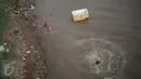 Seorang anak melompat dan berenang di aliran kali besar Banjir Kanal Barat, Jakarta, Sabtu (11/3). Tanpa mempedulikan kesehatan, sejumlah bocah tersebut terlihat asyik berenang di kali yang kondisi airnya keruh. (Liputan6.com/Faizal Fanani)