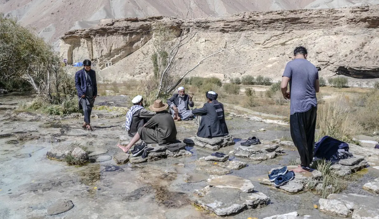 Wisatawan menikmati hari mereka di Danau Band e-Amir, Provinsi Bamiyan, 4 Oktober 2021. Danau Band-e Amir yang memiliki perairan biru menakjubkan disebut juga sebagai Grand Canyon Afghanistan. (BULENT KILIC/AFP)