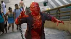 Peserta berdandan layaknya zombie dan menakut-nakuti orang selama acara Zombie Walk di Sao Paulo, Brasil, Sabtu (2/11/2019). Ratusan orang turun ke jalan memakai kostum karakter horor pada acara tahunan yang digelar sejak 2006 pada Hari Para Arwah. (Miguel SCHINCARIOL / AFP)