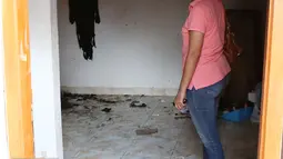 Pemilik kos melihat kamar kos-kosan terduga anggota jaringan teroris, Bekasi (11/12). Bom panci itu diamankan di kos yang dihuni oleh salah satu 'calon pengantin' bom bunuh diri, yakni perempuan berinisial DYN. (Liputan6.com/JohanTallo)
