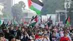 Sejumlah peserta aksi mengikuti aksi gerakan Global March to Gaza menuju kawasan Bundaran Hotel Indonesia, jalan MH Thamrin, Jakarta, Minggu (15/6/2025). (Liputan6.com/Herman Zakharia)