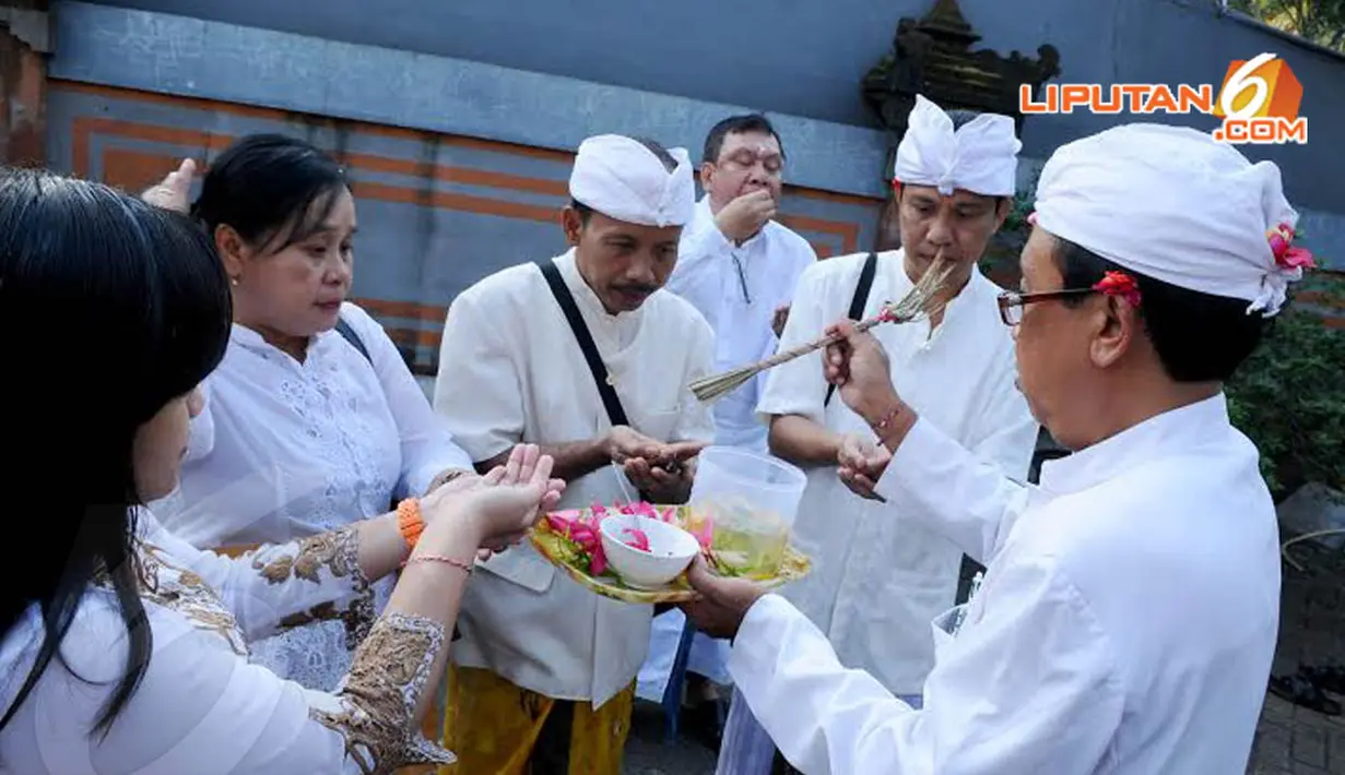  Pendeta Hindu tampak memercikkan tirta atau air suci pada umat Hindu yang akan melakukan sembahyang (Liputan6.com/Andrian M Tunay)