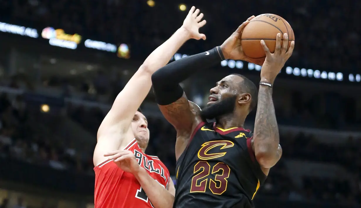 Pebasket Cleveland Cavaliers, LeBron James, dihadang pebasket Chicago Bulls, Paul Zipser, pada laga NBA di United Center, Selasa (5/12/2017). Cleveland Cavaliers menang 113-91 atas Chicago Bulls. (AP/Charles Rex Arbogast)