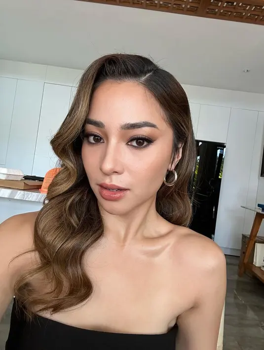 Gaya rambut bergelombang dan smokey makeup look buat penampilannya makin cantik. @nikitawillyofficial94.