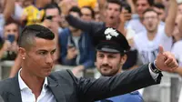 Bintang baru Juventus, Cristiano Ronaldo, menyapa suporter saat tiba untuk menjalani tes kesehatan di area Stadion Allianz, Turin, Senin (17/7/2018). CR 7 hijrah dari Real Madrid ke Juventus. (AFP/Miguel Medina)