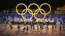 Para penari tampil di depan logo Olimpiade saat upacara pembukaan Olimpiade Tokyo 2020 di Olympic Stadium, Tokyo, Jepang, Jumat (23/7/2021). (Foto: AP/Pool/Dylan Martinez)