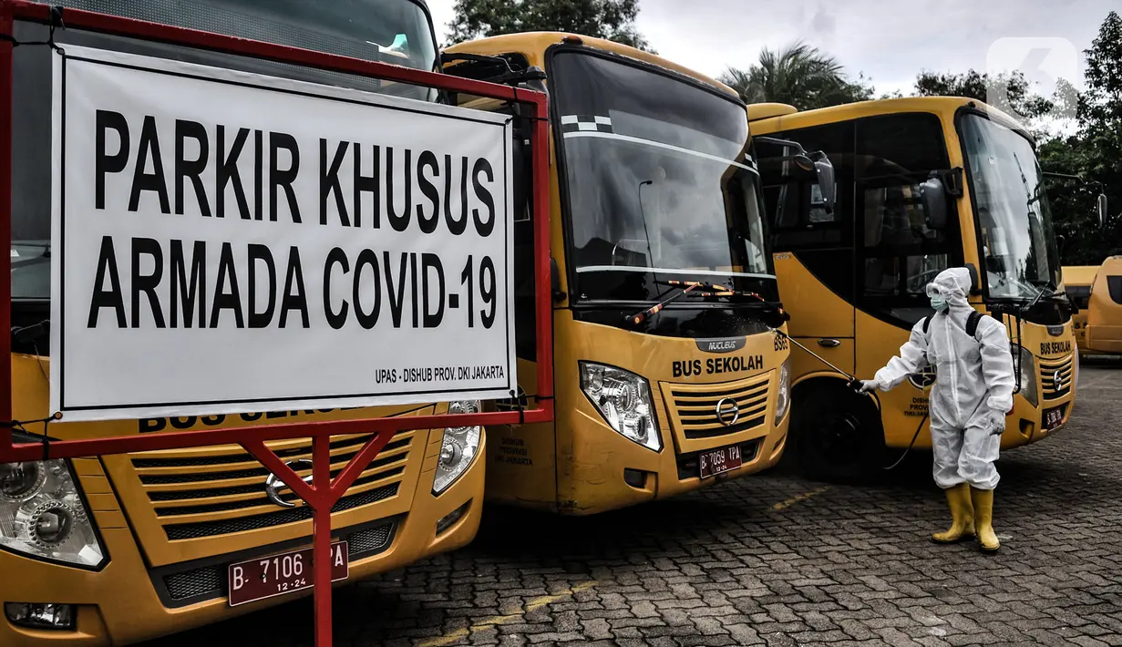 Petugas Kebersihan Bus (PKB) menyemprotkan disinfektan pada bus sekolah di Pool Unit Pelayanan Angkutan Sekolah (UPAS) DKI Jakarta, Kramat Jati, Selasa (5/1/2021). Sterilisasi bus sekolah rutin dilakukan usai digunakan mengangkut pasien terpapar Covid-19 ke RS rujukan. (merdeka.com/Iqbal Nugroho)