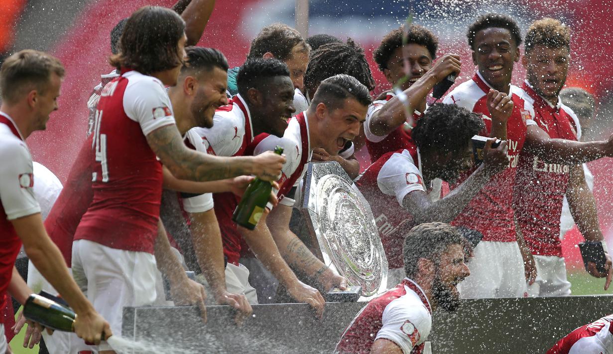 Para pemain Arsenal menyemprot sampanye saat merayakan gelar Community Shield usai mengalahkan Chelsea di Stadion Wembley, London, Minggu (6/8/2017). Ini merupakan trofi Community Shield yang ke-15 bagi Arsenal. (AFP/Ian Kington)