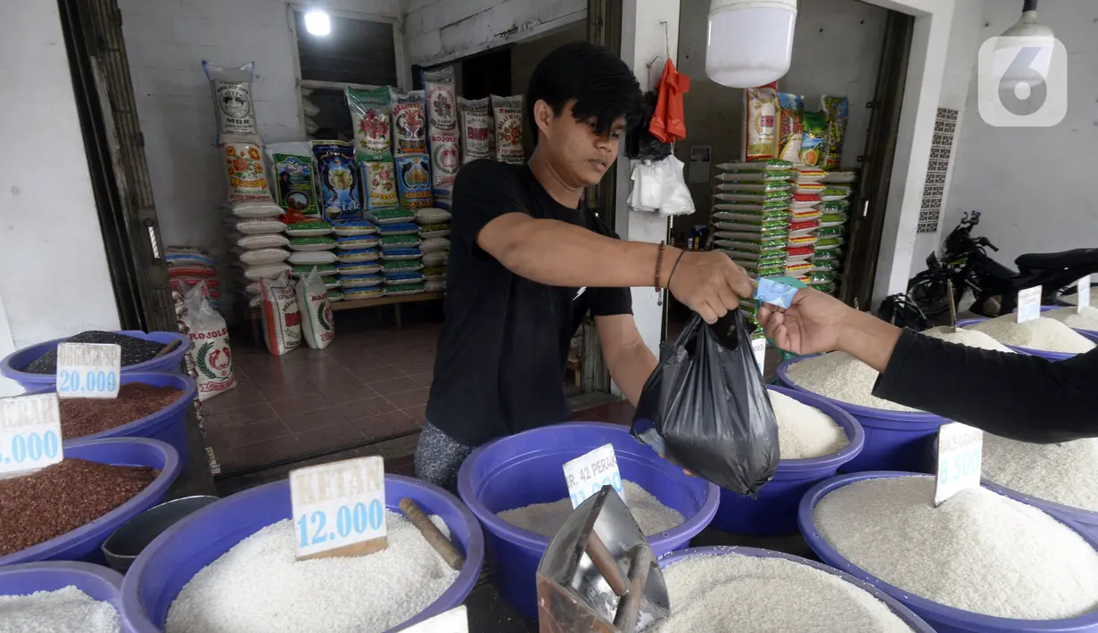 Pedagang beras bertransaksi dengan pembeli di pinggir Jalan Raya Pamulang, Tangerang Selatan, Banten, Jumat (11/12/2020). Jelang Natal dan Tahun Baru 2021, harga beras dipasaran masih normal tidak ada kenaikan. (merdeka.com/Dwi Narwoko)