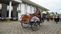 Menteri Energi dan Sumber Daya Mineral (ESDM) Ignasius Jonan menaiki becak listrik di Kampus UGM, Yogyakarta. (Dok Kementerian ESDM)