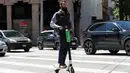 Seorang pria mengendarai skuter bermotor di jalanan di San Francisco (17/4). Pemberhentian operasi skuter bermotor ini karena belum adanya kepastian terhadap keamanan dan keselamatan penggunaan skuter di tempat umum. (AP/Jeff Chiu)
