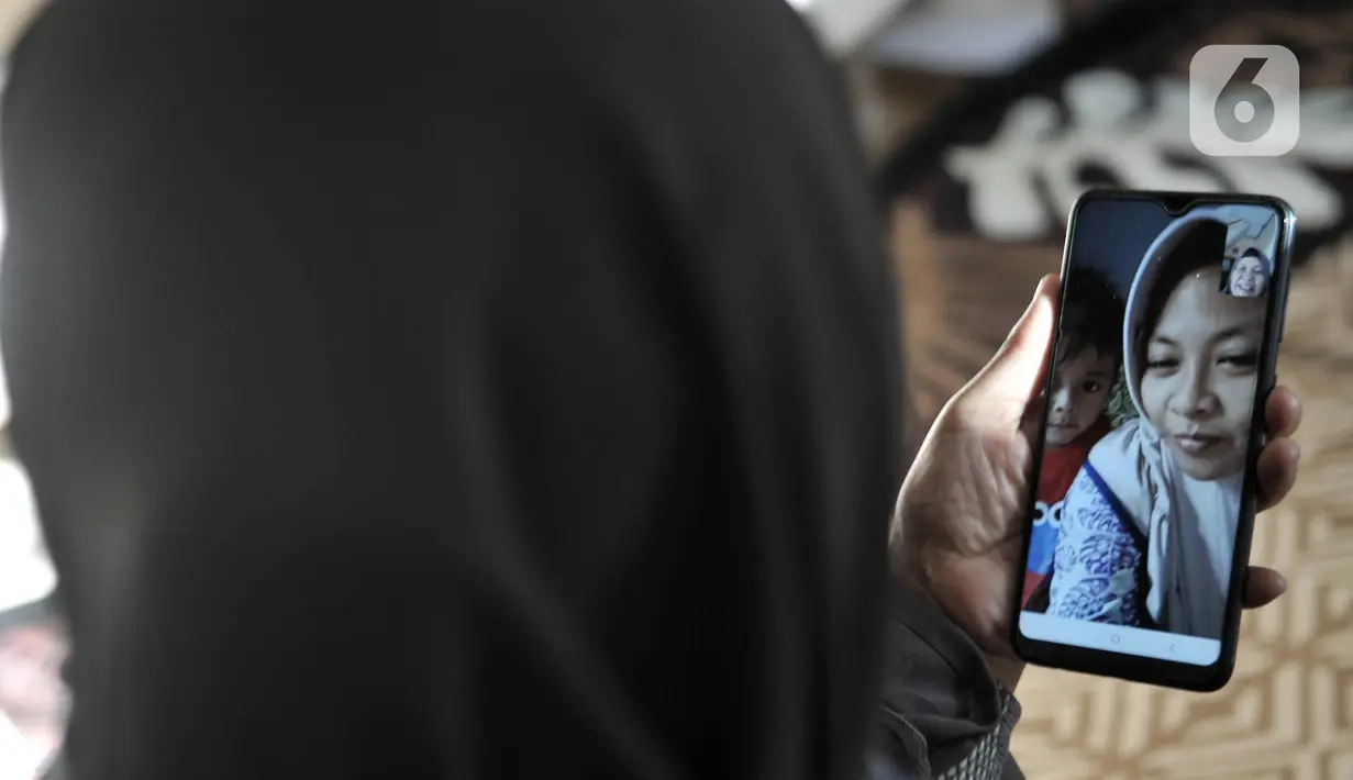 Warga bermaaf-maafan dengan keluarga melalui panggilan video saat halalbihalal Idul Fitri di Jakarta, Minggu (24/5/2020). Halalbihalal virtual menjadi alternatif bersilaturahmi dengan keluarga di kampung halaman akibat tidak dapat mudik karena wabah virus COVID-19. (merdeka.com/Iqbal S. Nugroho)