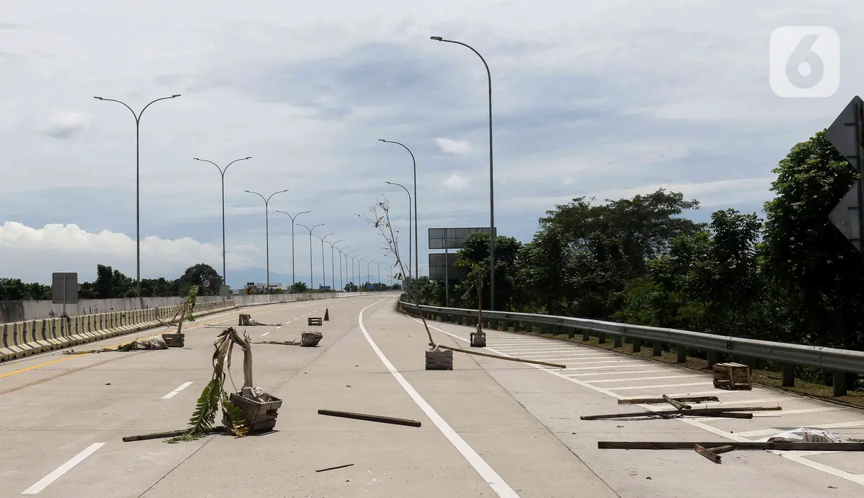 Sejumlah pohon diletakan saat aksi menutup akses jalan menuju Gerbang Tol (GT) Jatikarya 1& 2, di Jalan tol Cimanggis-Cibitung, Bekasi, Jawa Barat, Rabu (8/2/2023). Dalam aksinya mereka menuntut Pengadilan Negeri Kota Bekasi segera menyelesaikan pembayaran atas penggunaan tanah untuk tol seluas 4,2 hektar. (Liputan6.com/Herman Zakharia)
