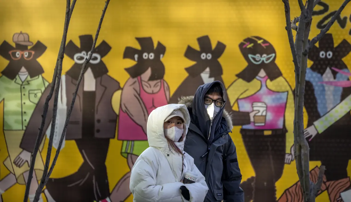 Pengunjung yang mengenakan masker berjalan melalui pusat perbelanjaan kelas atas pada hari terakhir minggu liburan Tahun Baru Imlek di Beijing, Jumat, 27 Januari 2023.