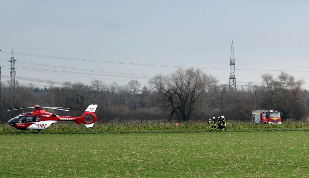 Polisi dan regu penyelamat mengamankan area lokasi terjadinya kecelakaan udara antara pesawat kecil dengan helikopter di Philippsburg, Jerman, Selasa (23/1). Puing-puing dua badan pesawat udara jatuh dalam wilayah yang cukup luas  (Rene Priebe/dpa via AP)